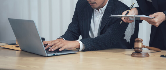 Legal Counsel: A serious lawyer, clad in a professional suit, intently focuses on their laptop...