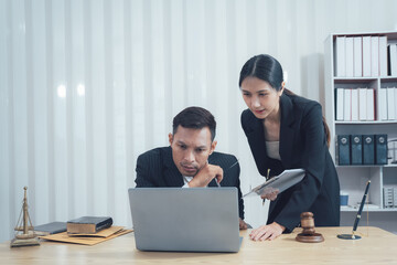 Legal Consultation: A serious lawyer and paralegal work together on a case, reviewing documents and collaborating on legal strategy. This image conveys the professionalism, commitment.