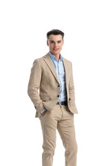 happy student wearing beige suit standing and holding pockets