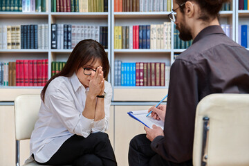 Mature serious sad woman at meeting in office of psychologist, social worker
