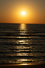 Golden sunset over the ocean with shimmering reflections on the waves.