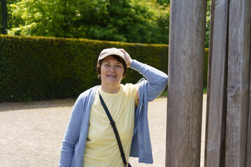 Positive Elderly woman in a sweater in the summer in the park. Concept of an active and healthy retiree