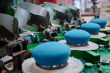 Creating vibrantly colored blue berets in a felt factory, showcasing artistry and precision in textile production