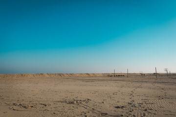 Empty Sandy Beach with Blue Sky and Minimalist Structures