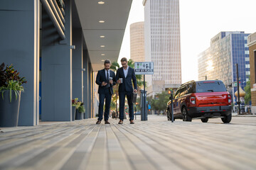 Obraz premium Success. Businessmen in suit walking outdoor. Two businessmen walking and talking in the city. Business men talking. Walking and talking two business men. Colleague walk in New York, Manhattan