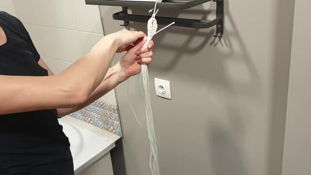 Time lapse footage of the woman weaving macrame flowerpot. Hobby