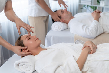 Obraz premium Caucasian couple enjoying relaxing anti-stress head massage and pampering facial beauty skin recreation leisure in dayspa modern light ambient at luxury resort or hotel spa salon. Quiescent
