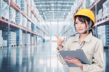 大きな物流倉庫で働くヘルメットを被った若い女性