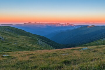 Obraz premium Sunset over rolling hills and distant mountains