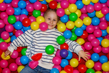 Obraz premium Kid enjoying playtime in a colorful ball pit at an indoor playground during the afternoon. Top view