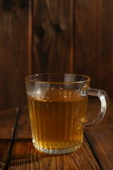 Refreshing green tea in cup on wooden table, closeup