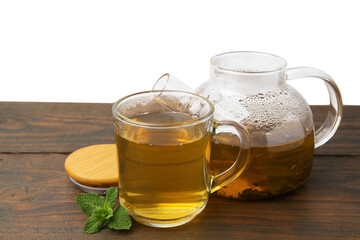 Aromatic mint tea and fresh leaves on wooden table against white background