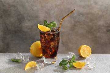 Fresh iced cola with mint and lemons on grey table