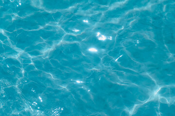 Overhead view of blue water surface abstract. Wave on moving water surface close up in the middle of the screen. Blue ocean water with waves background