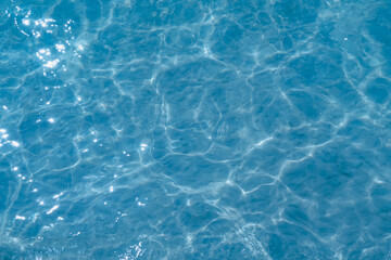 Overhead view of blue water surface abstract. Wave on moving water surface close up in the middle of the screen. Blue ocean water with waves background