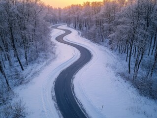 A winding, snow-covered country road on a cold winter's day. Curved path through the woods.