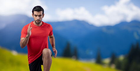 Fototapeta premium Athletic and sporty man running posture at outdoor mountain exercise session for fit physique and healthy outdoor sport lifestyle. Gaiety green natural exercise workout training.