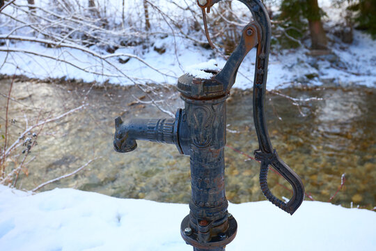 Historic Hand Pump Covered with Snow