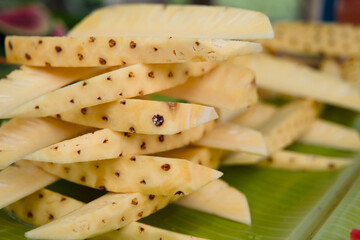 Pineapple slices on a banana leaf close up view