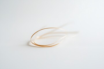 A delicate golden ribbon curved on a white background