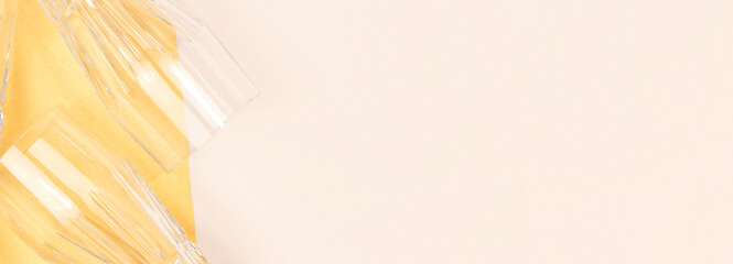 Banner with empty crystal glasses on a beige and golden background.