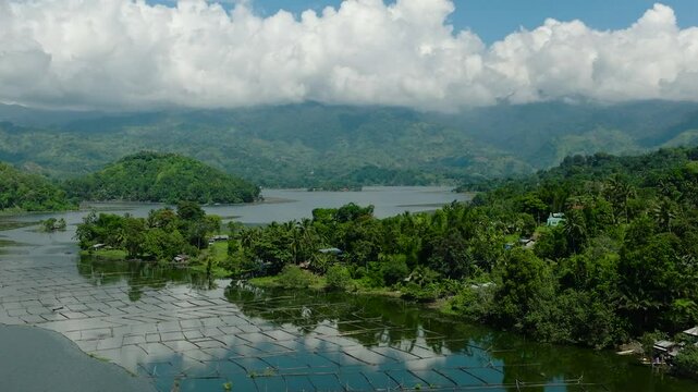 Agricultural landscape with fish farm over Lake Sebu and rainforest, green trees. Mindanao, Philippines.