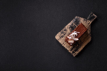 Piece of sweet chocolate bounty cake with coconut flakes and sponge