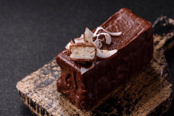 Piece of sweet chocolate bounty cake with coconut flakes and sponge