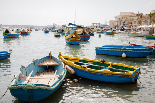Colorful traditional maltese luzzu boats moored near Marsaxlokk fishers village on Malta