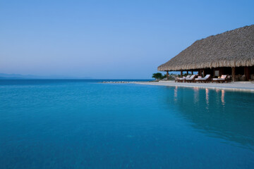 Fototapeta premium A beach house with a pool and a beach in the background