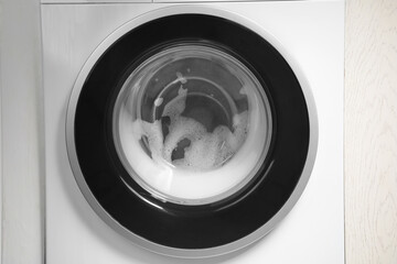 Washing machine with suds as background, closeup
