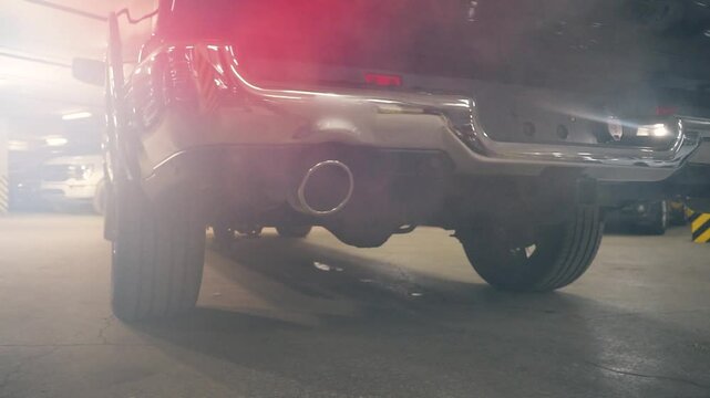 Car exhaust fumes before driving. A view of a working car with car exhaust fumes in the parking lot.