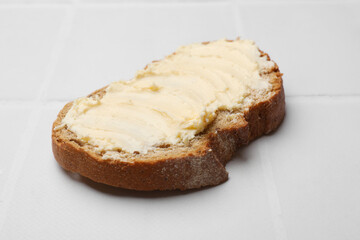 Fresh bread with butter on white tiled table, closeup