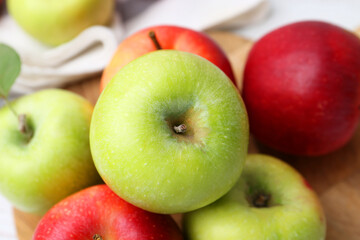 Different whole ripe apples on wooden table, closeup