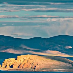Naklejka premium Desert mountain landscape with blue sky and misty valley