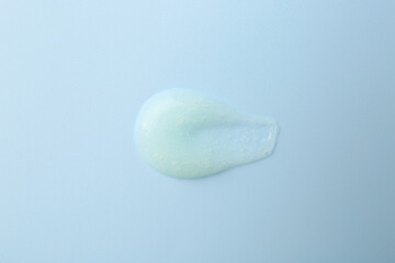 Smear of body scrub on light blue background, top view