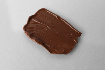 Sample of foundation on light grey background, closeup