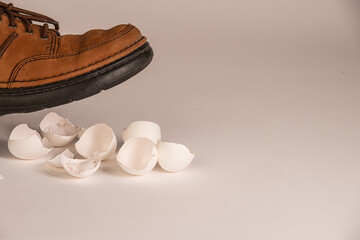 Shoe over broken eggshells, conceptual image about dealing with a difficult touchy situation or person.