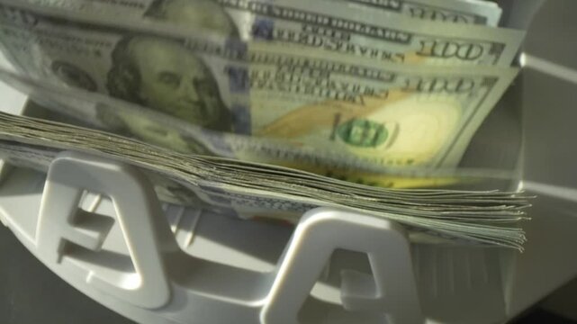Macro shot counter counting dollar bills. Money counting machine with 100 dollar banknotes. Bank currency and finance. Close up cash money dollars counting. Crisis business, inflation concept.