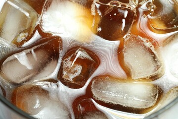 Refreshing coffee with ice and milk in glass, top view