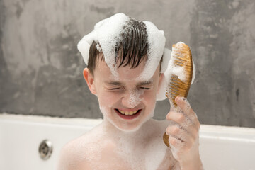 Smiling child enjoying bath time with foam on his head and face, playfully holding a wooden comb. This fun moment showcases children's hygiene habits, family routines, and happy childhood.