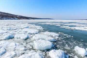 Ice floes drift on the river's surface, surrounded by a serene winter landscape