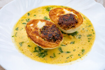 Les Oeufs Jeannette (Eggs Jeannette) with special filling and yellow sauce, vegetarian food
