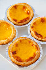 Portugal's traditional sweet dessert Pastel de nata egg custard tart pastry in cup close up
