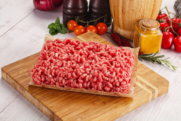 Raw minced beef meat over board