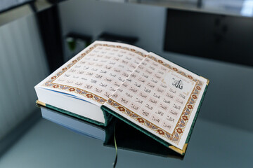 Open Quran Featuring Arabic Script With Blue Decorative Details.