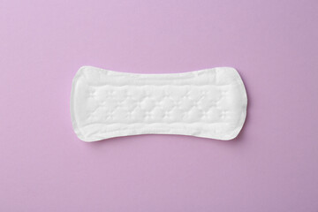 Menstrual pad on lilac background, top view