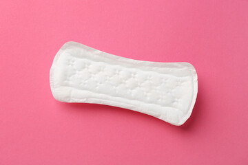 Menstrual pad on pink background, top view