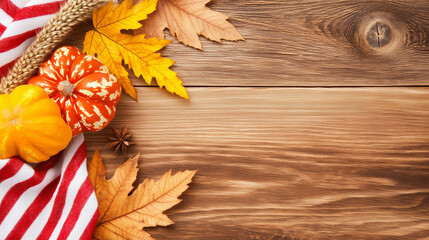 A rustic wooden background adorned with autumn leaves, small pumpkins, and a red and white striped cloth. The scene captures the essence of fall and harvest.