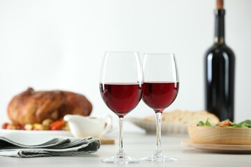 Red wine and delicious dinner served on light table